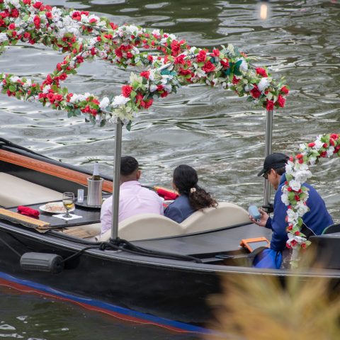 a group of people riding on the back of a boat in the water